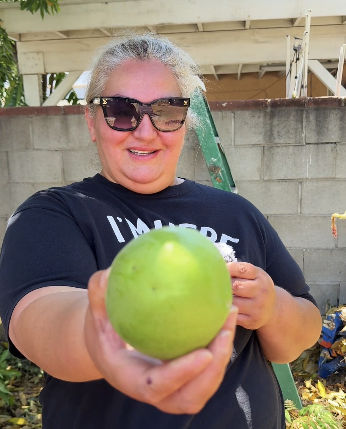 Nanette, a featured PickFresh seller, holding a sapote from her backyard garden